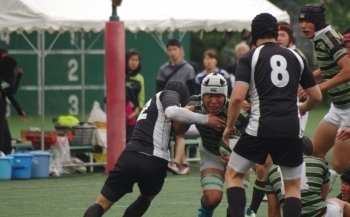 Captain Matsuki pushes forward while being tackled