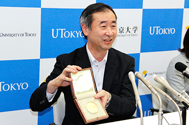 Professor Kajita happily shows his Nobel Medal to the press        (*The Nobel Prize Medal is a copyright and registered trademark of the Nobel Foundation.)