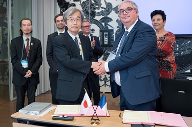ERI Director Kazushige Obara, at left foreground, and BRGM Deputy CEO Pierre Toulhoat clasp hands at an MoU signing ceremony between their institutions, at the French Embassy in Tokyo on October 2. From the right at back, French Higher Education, Research and Innovation Minister Frédérique Vidal, French Ambassador Laurent Pic, Science and Technology Attaché Sébastien Codina, and ERI’s Professor Hiroyuki Tanaka look on.