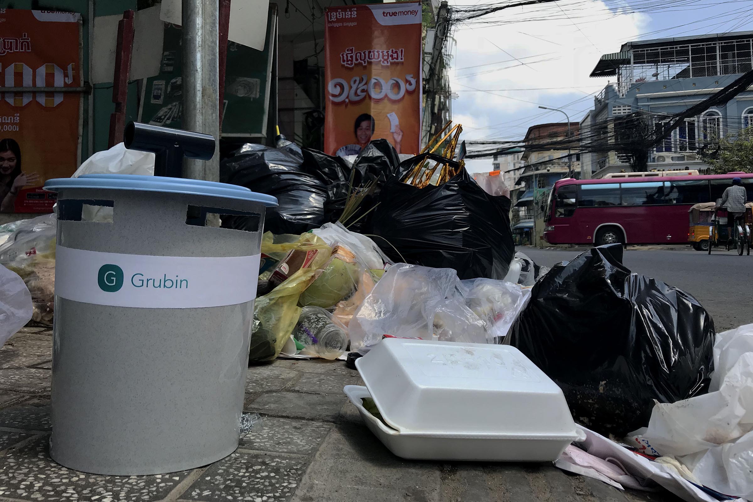 A Grubin in front of a trash pile along a street in Phnom Penh, Cambodia