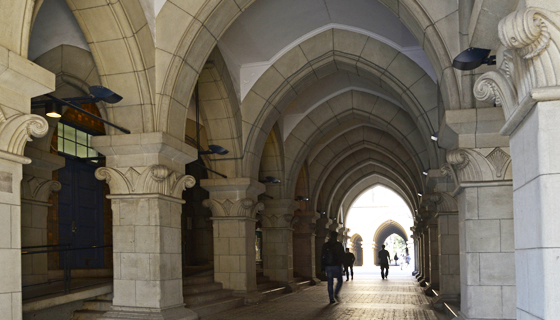 An arched passageway with people walking through it