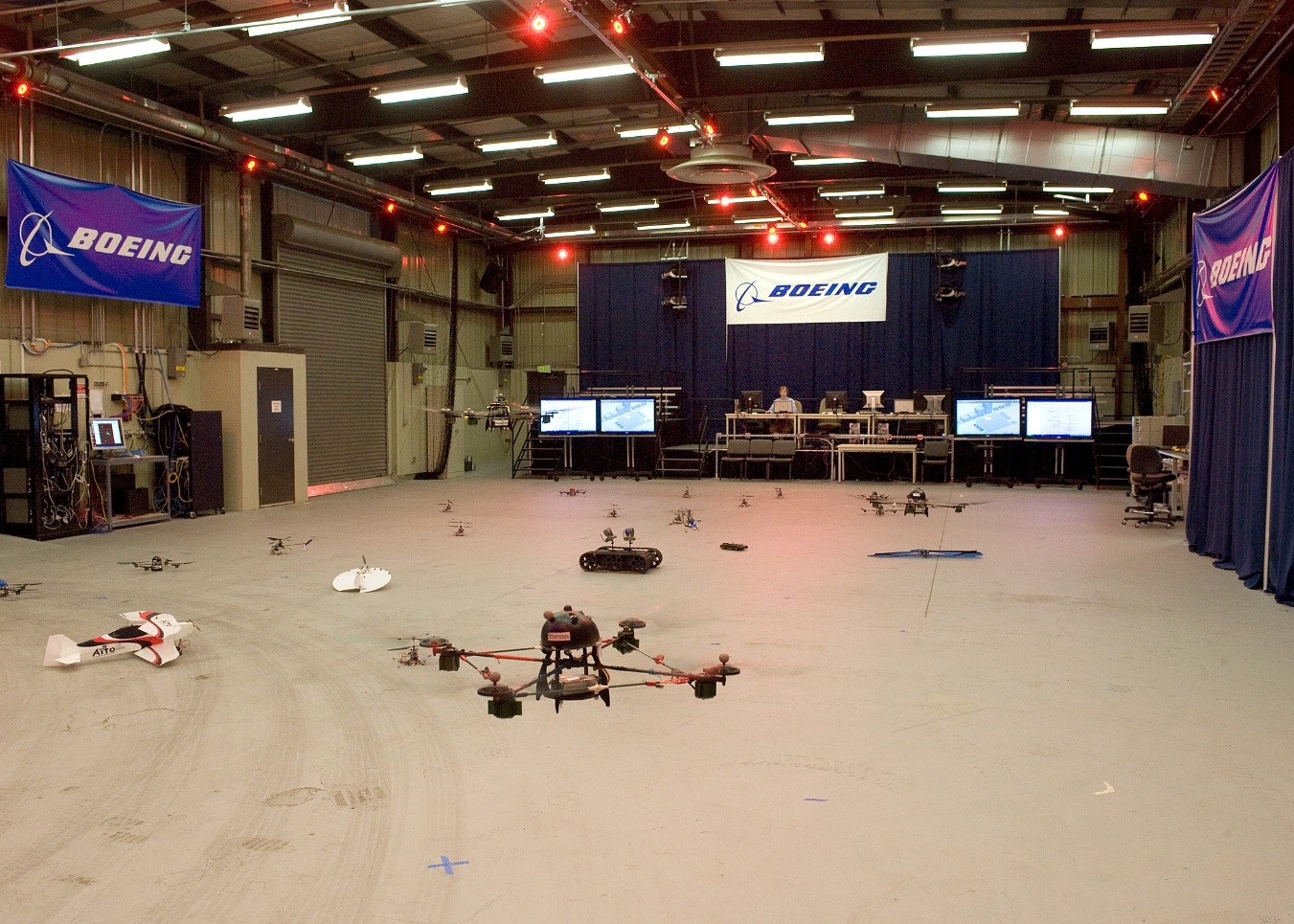 Fig. 3: The test facility at Boeing in Seattle. The red lights in the ceiling indicate where the cameras used by the external vision system are located.