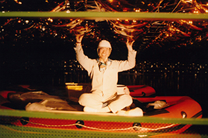 Sitting on a rubber raft, a young Professor Kajita adds the finishing touches to the ceiling of the Super-Kamiokande after the facility was filled with water.