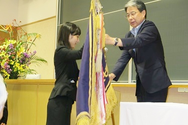 Pennant being awarded by Executive Vice President Tomokazu Haebara (Picture provided by Gakushi-kai)