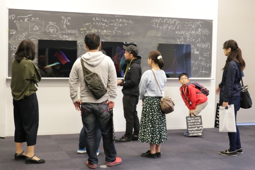 Hirakawa and visitors in front of his exhibition during the Open Days event at the Kashiwa Campus