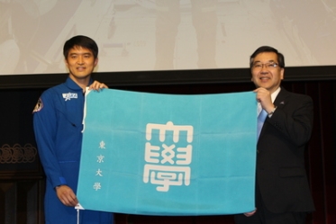 Astronaut Onishi and President Gonokami holding the University of Tokyo flag that was taken into space