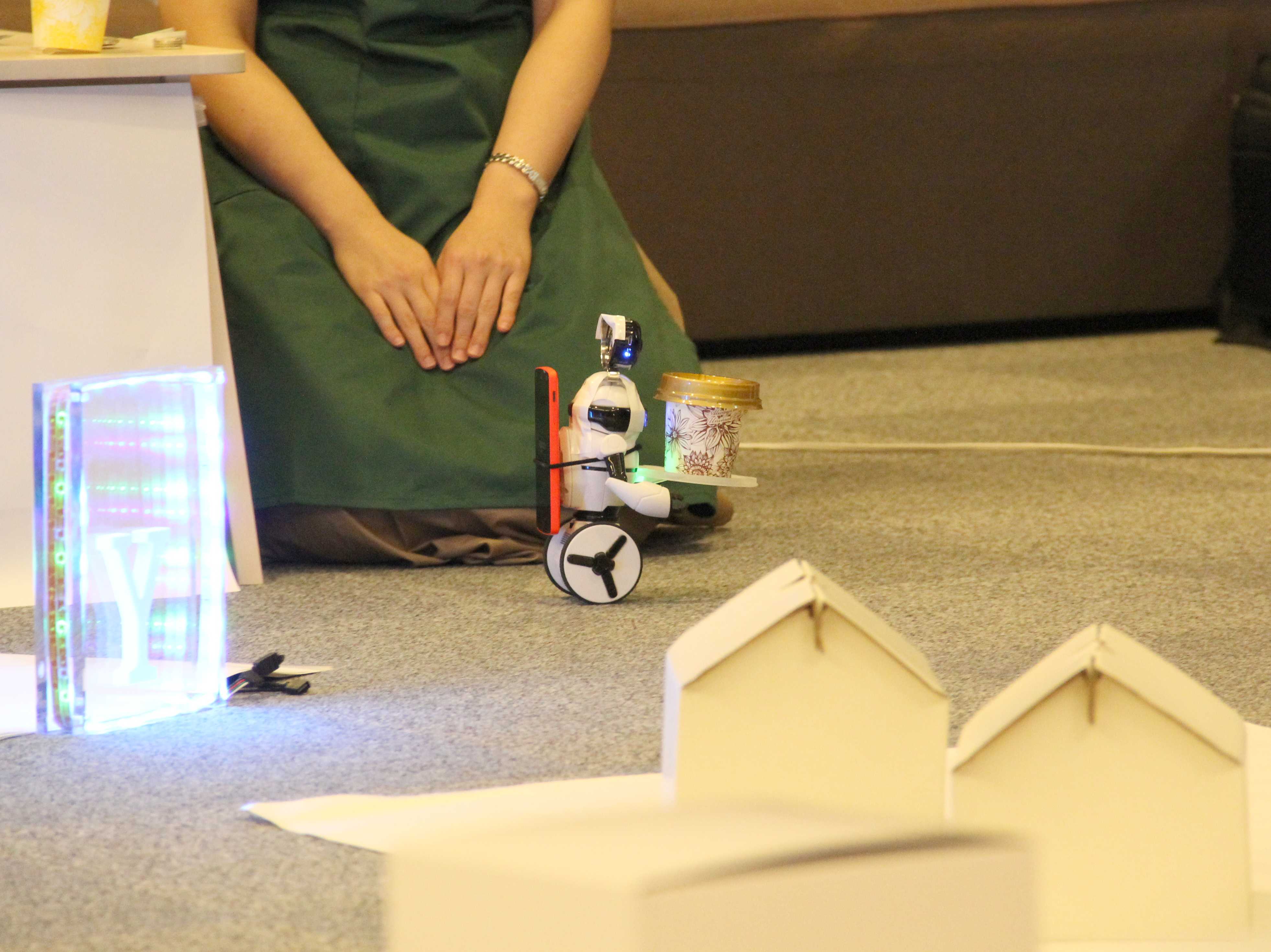 A small robot holding a paper cup