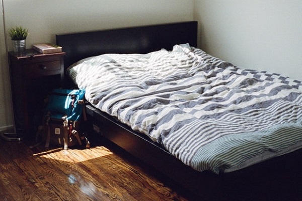 A photo of an empty bed with blue and white striped sheets
