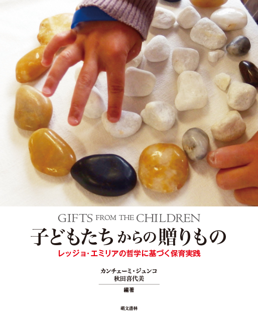 A picture of kid playing with stones on a white cover