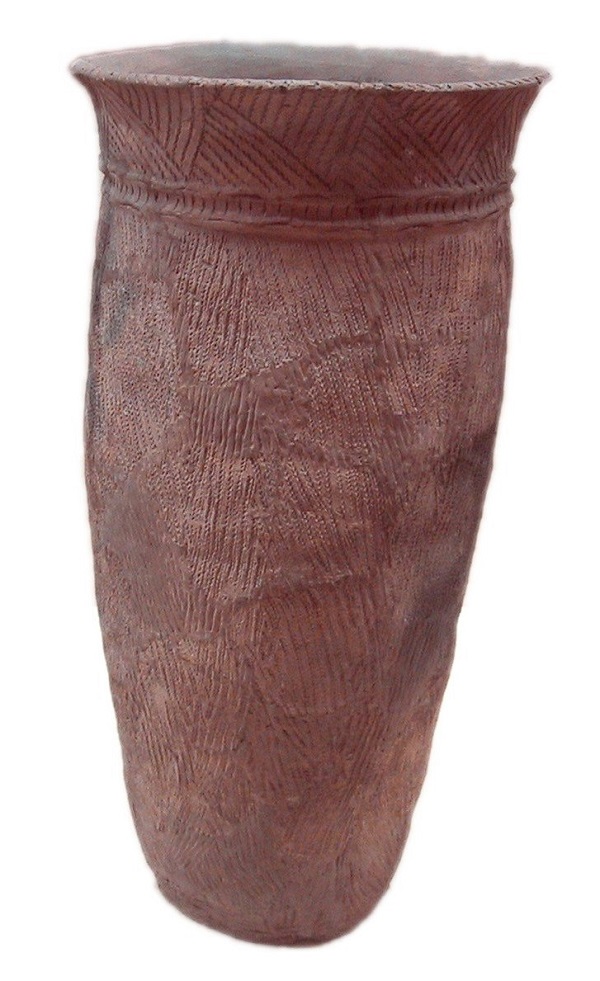 Redish brown, unpainted clay vase covered in patterns made by pressing rope into the wet clay. 