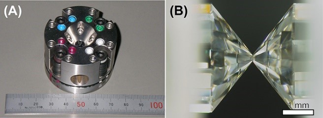 (left) a circular metal shape. (right) two pointed crystal shapes touch on a black background