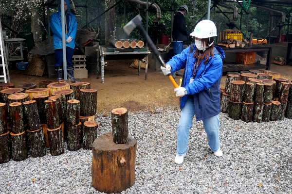 Student outside holding an axe