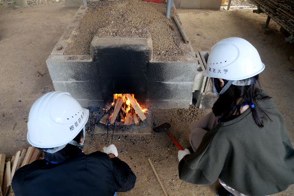 Two students in front of a kiln
