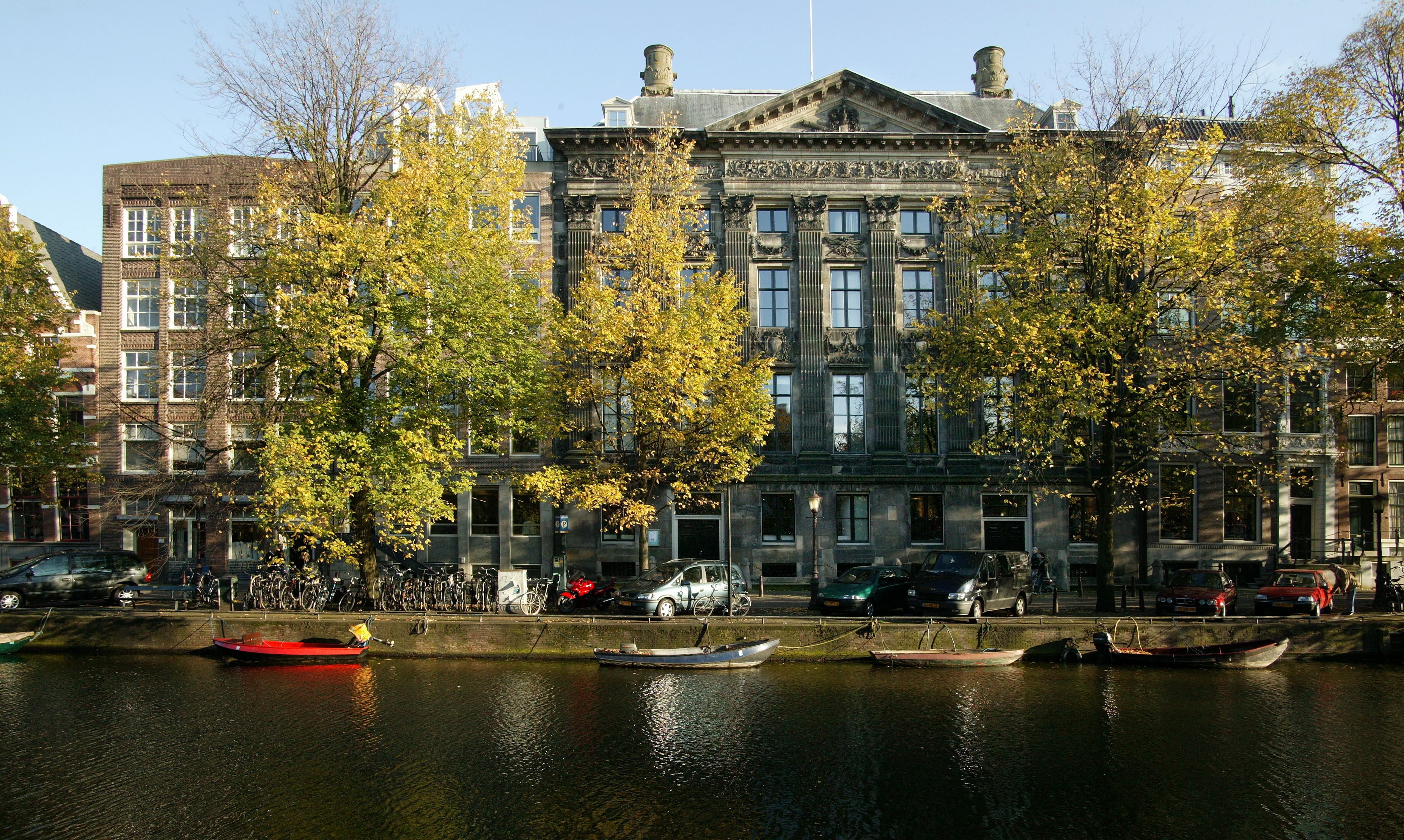 A historic building surrounded by trees next to a river