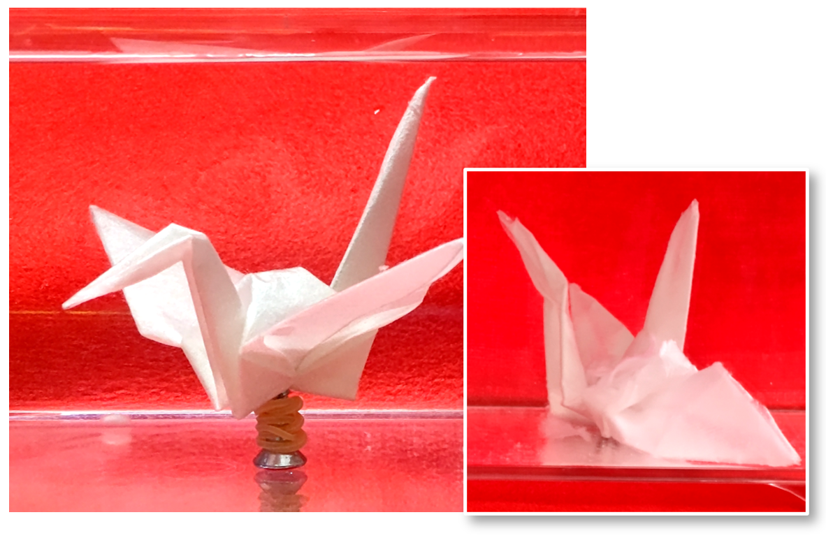 A red background. Two white origami cranes