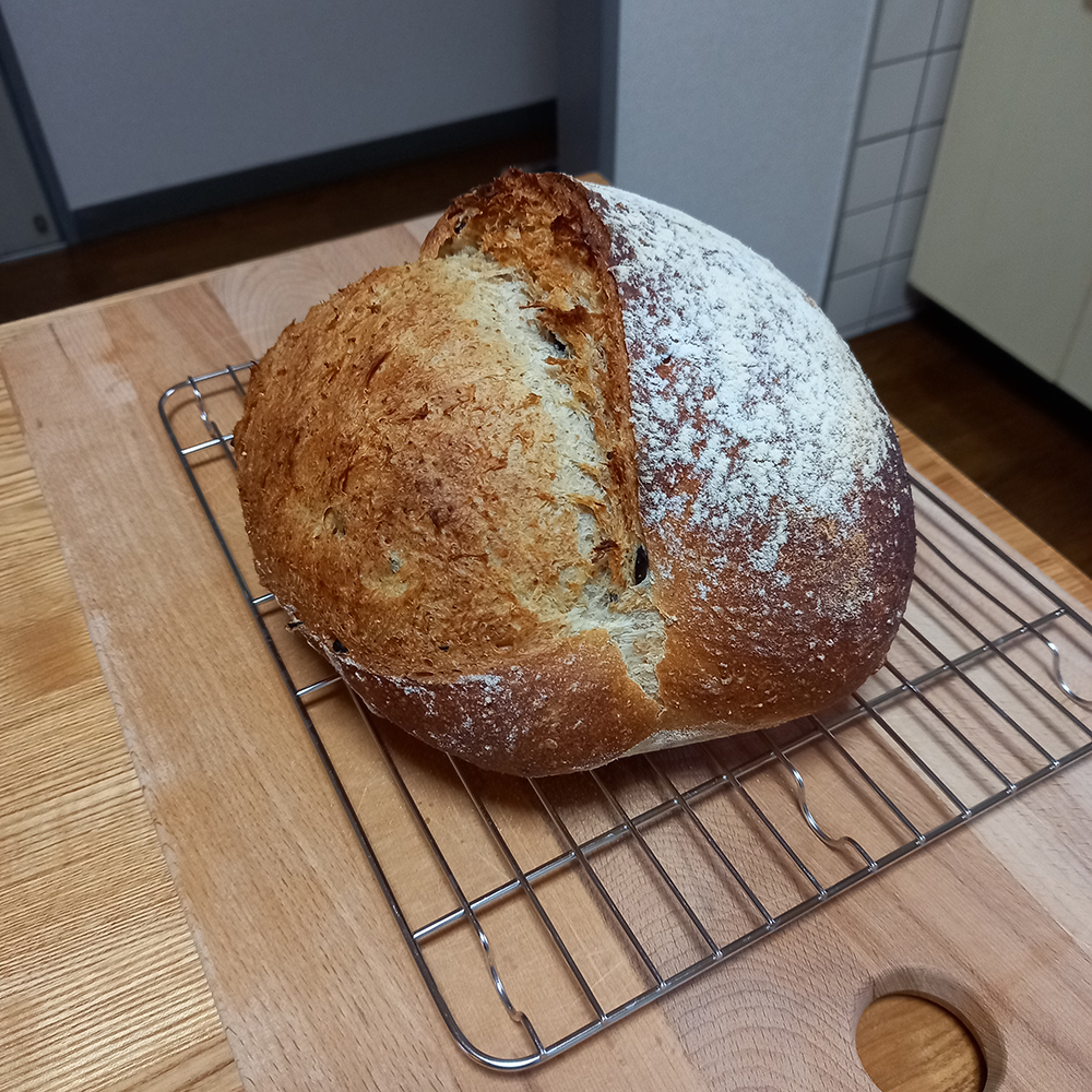 Home baked round loaf of bread on a kitchen table.