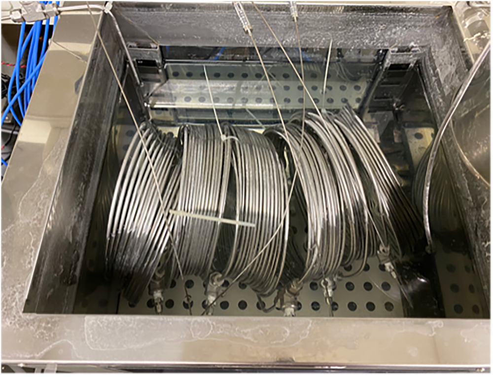 A photograph of the metal coil used, in a water bath in the lab.