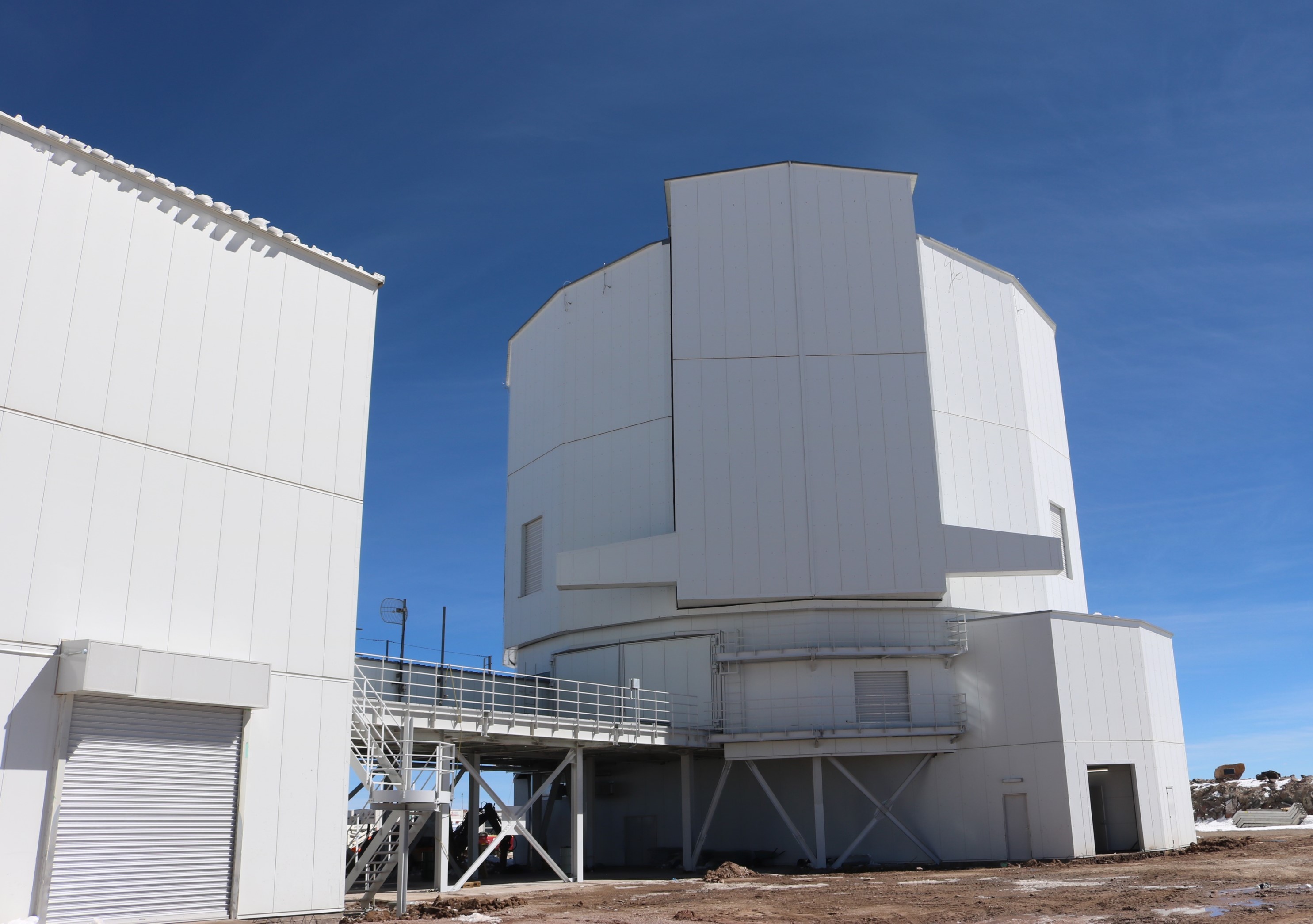 A large white metal building against a blue sky.