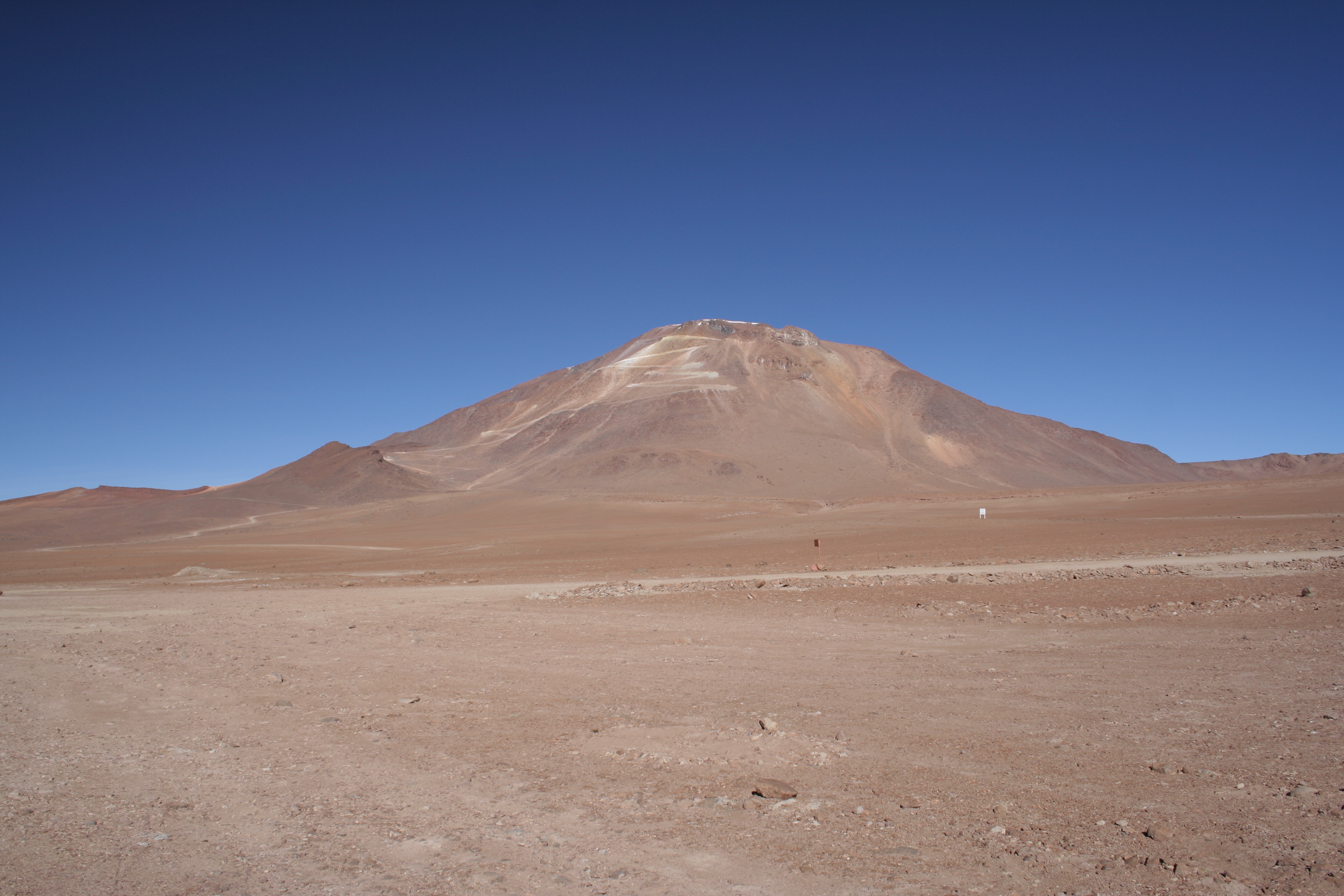 A brown mountain against a blue sky.