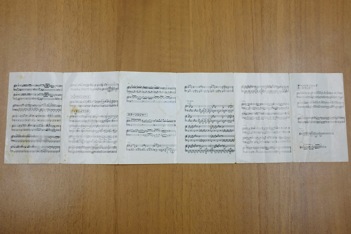 『ハドソン・ゲーム・ミュージック』（アルファレコード 1986 テープ版）に同封された楽譜が6枚並べられている