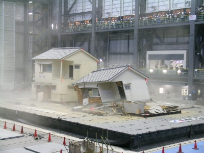 A wooden house on which seismic reinforcement work was done (left) and a wooden house without any reinforcement (right) photographed after being shaken violently in a large earthquake. The reinforced house did not collapse, and will protect the lives of its occupants.