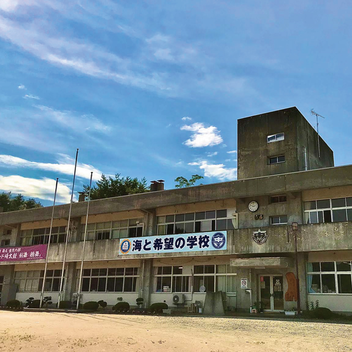 「海と希望の学校」の横断幕が掲げられた宮古市立重茂中学校の校舎