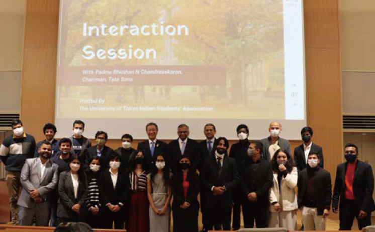 「Interaction Session」のスライド映像が映し出されたスクリーンの前に集合するインド人留学生ら