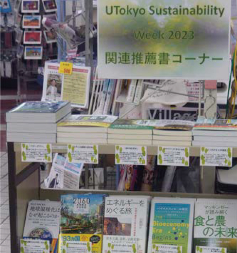 「UTokyo Sustainability Week 2023 関連推薦書コーナー」と書かれた貼り紙とブックワゴンに並んだ書籍