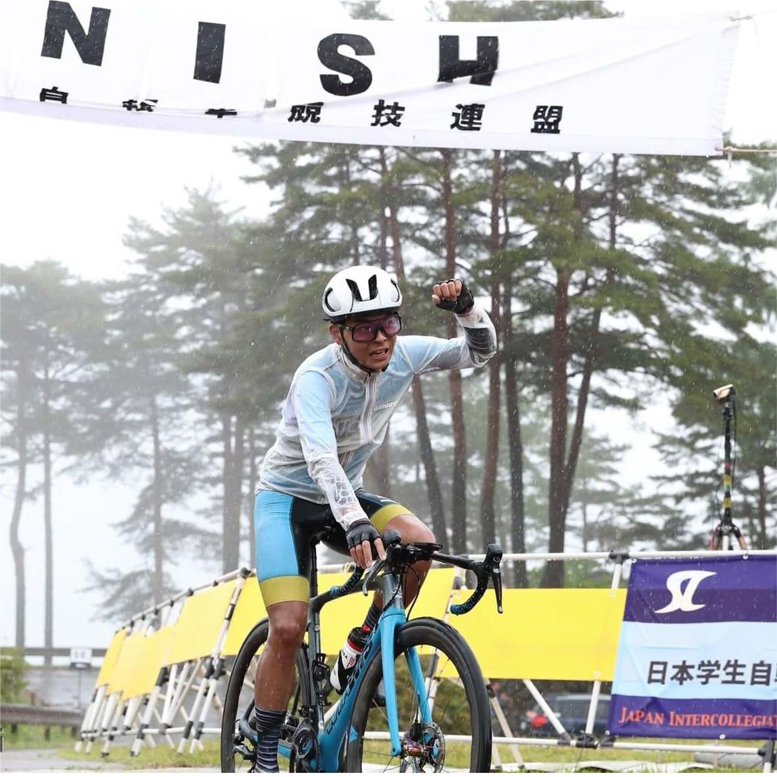 ロードレース用の自転車に乗って左手の拳を挙げている篠﨑蒼平選手