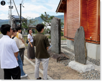 明治三陸と昭和三陸の津波伝承碑についての説明を受ける学生。