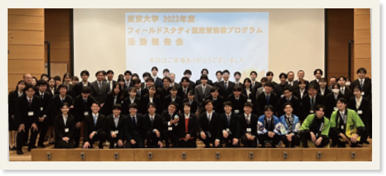 壇上のスクリーンの手前に並んだ報告会の参加者