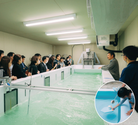 小さなプールのような氷海造波水槽。周りに人々が集まっている