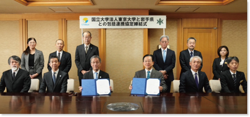 締結式典の集合写真の様子。藤井総長と達増知事がそれぞれ協定書を手に持っている
