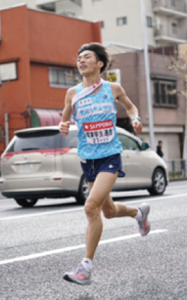 建物や車がある道路を走る古川選手