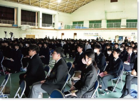 体育館で椅子に座っている大勢の学生の様子