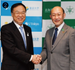 ❷握手を交わす大久保氏（左）と横田氏（右）
